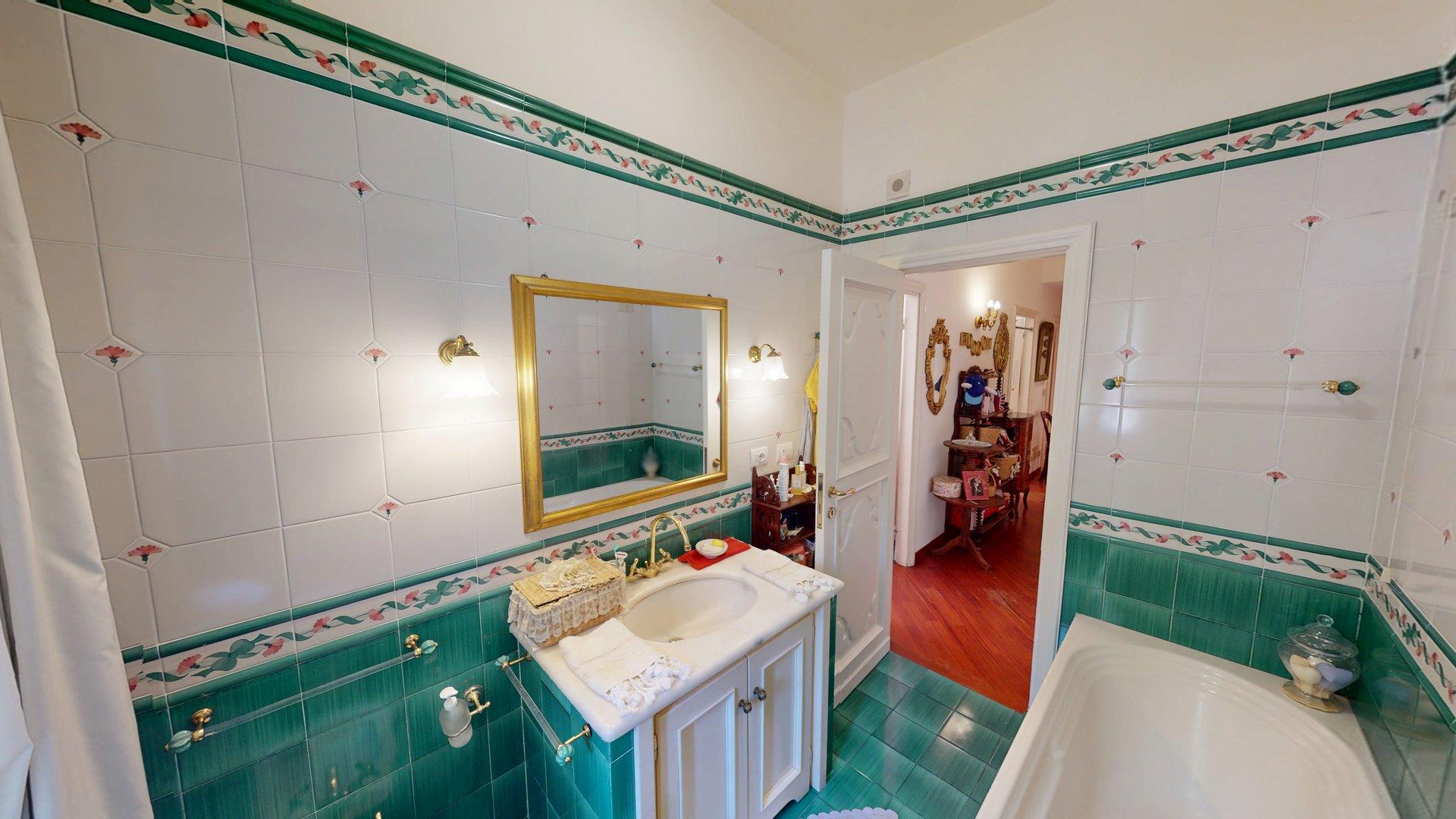 Il bagno principale con maioliche verdi